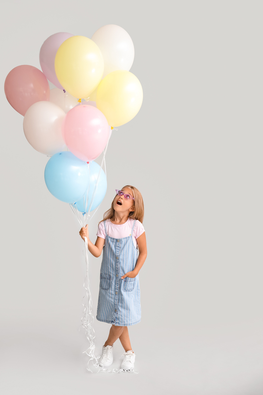 Little Girl with Balloons on Grey Background